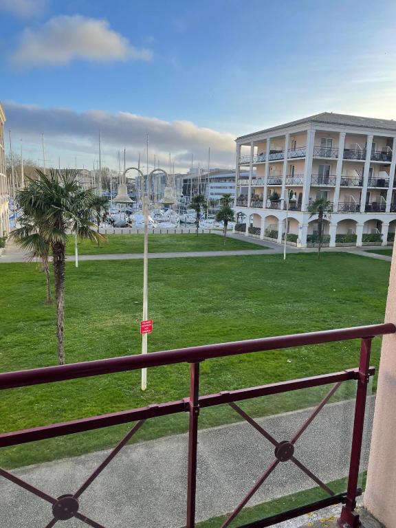 - un balcon offrant une vue sur un grand bâtiment dans l'établissement Agréable appartement vue sur port de plaisance, à Rochefort