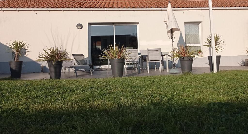 d'une terrasse avec une table, des chaises et un drapeau. dans l'établissement Le havre des Sables, à Les Sables-dʼOlonne