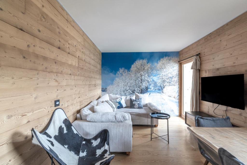 un salon avec un canapé et une télévision dans l'établissement Le Chappart - Carroz d'Arâches, à Arâches-la-Frasse