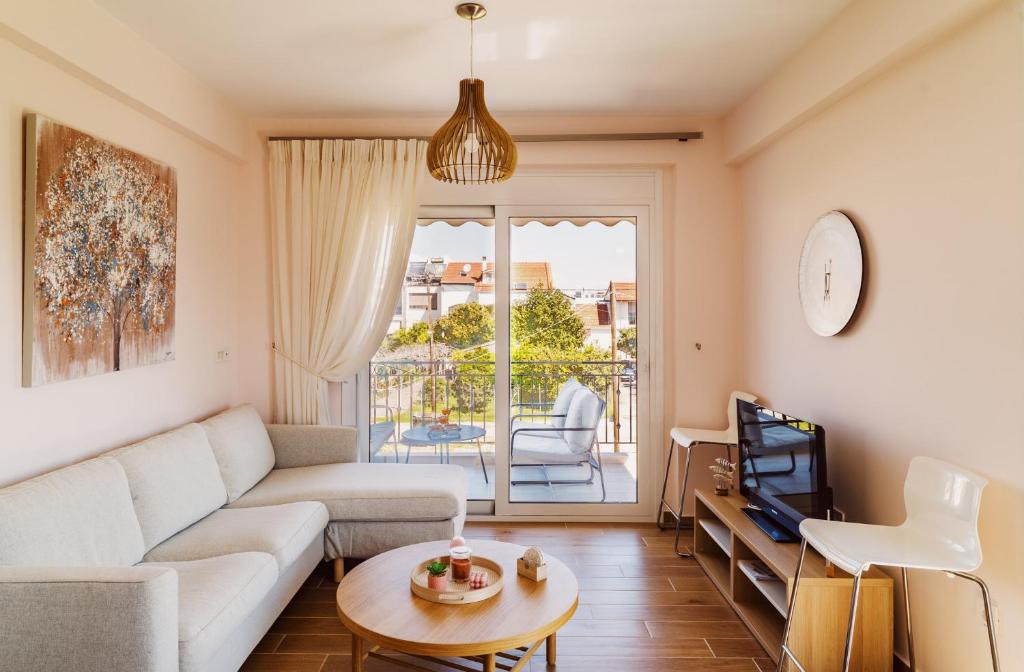 a living room with a couch and a tv at K&E Guesthouse in Preveza