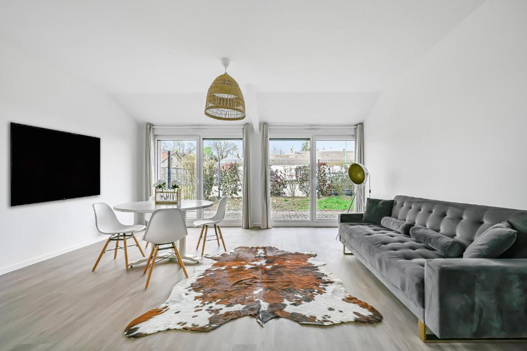 un salon avec un canapé et une table dans l'établissement La Familia - 5 pers - Jardin - Wifi, à Évreux