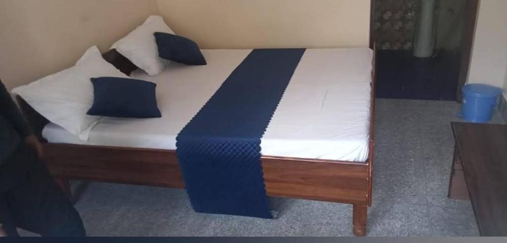 a bed with blue and white sheets and pillows at New Yamunotri homestay by Preet rS in Barkot