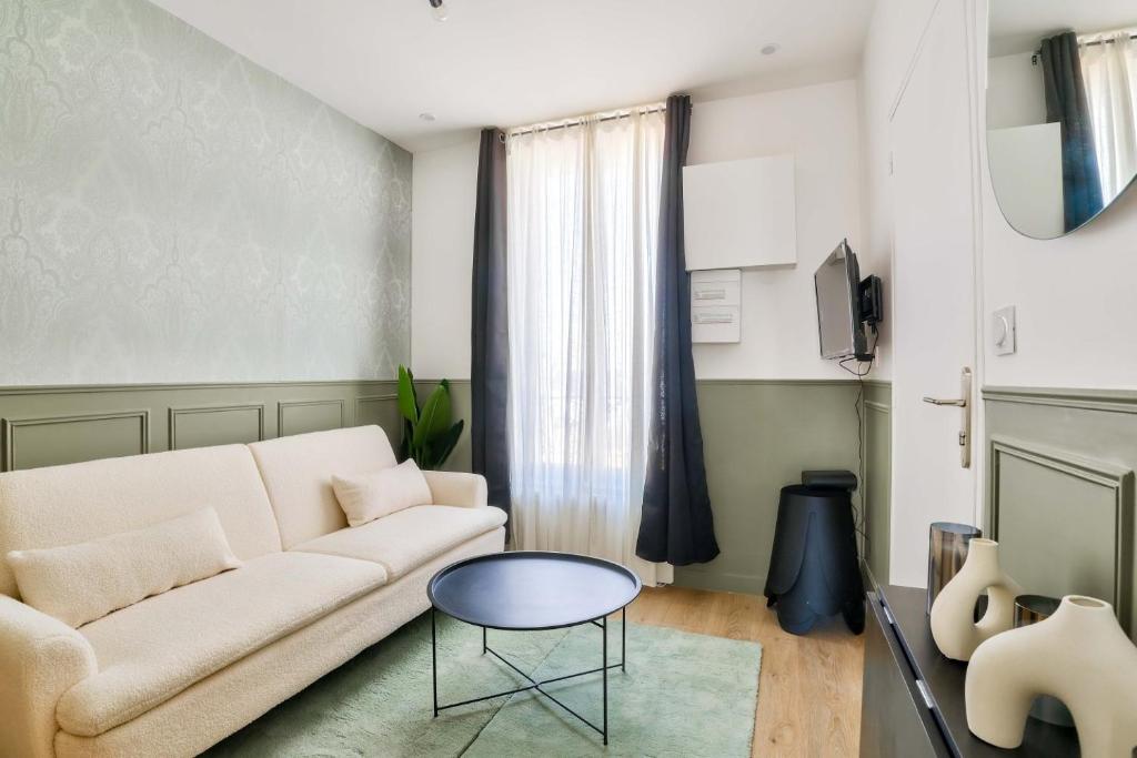 un salon avec un canapé blanc et une table dans l'établissement GuestReady - Charm and Comfort near Paris, à Bagneux