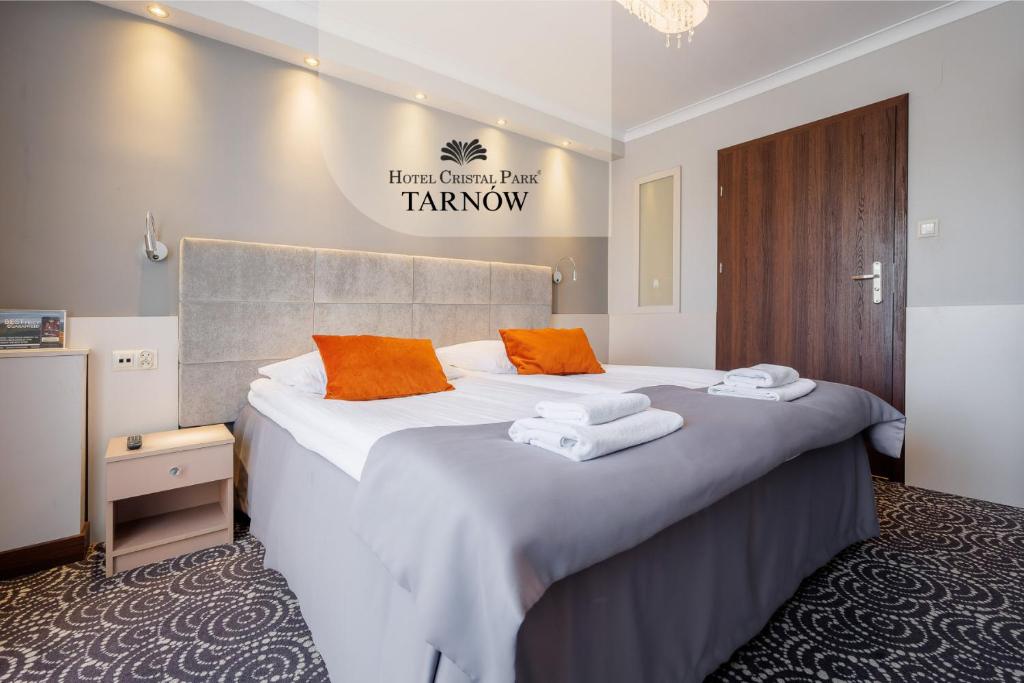 Una habitación de hotel con una cama grande y toallas. en Hotel Cristal Park, en Tarnów