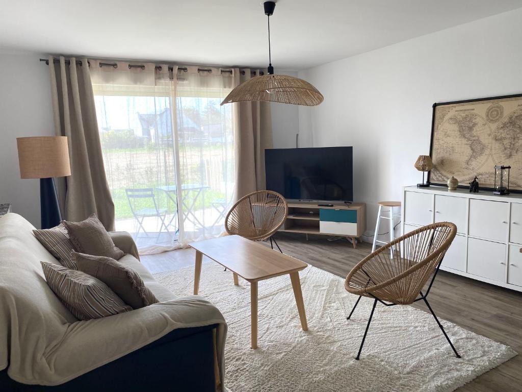 un salon avec un canapé, des chaises et une télévision dans l'établissement Le Lanroz beau T2 dans résidence privée Lambezellec, à Brest
