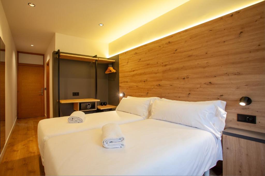 a bedroom with a large white bed with towels on it at Plaza Obradoiro Express by Bossh! Hotels in Santiago de Compostela