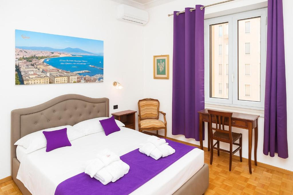 a bedroom with a bed and a window with purple curtains at Suite Cervantes in Naples