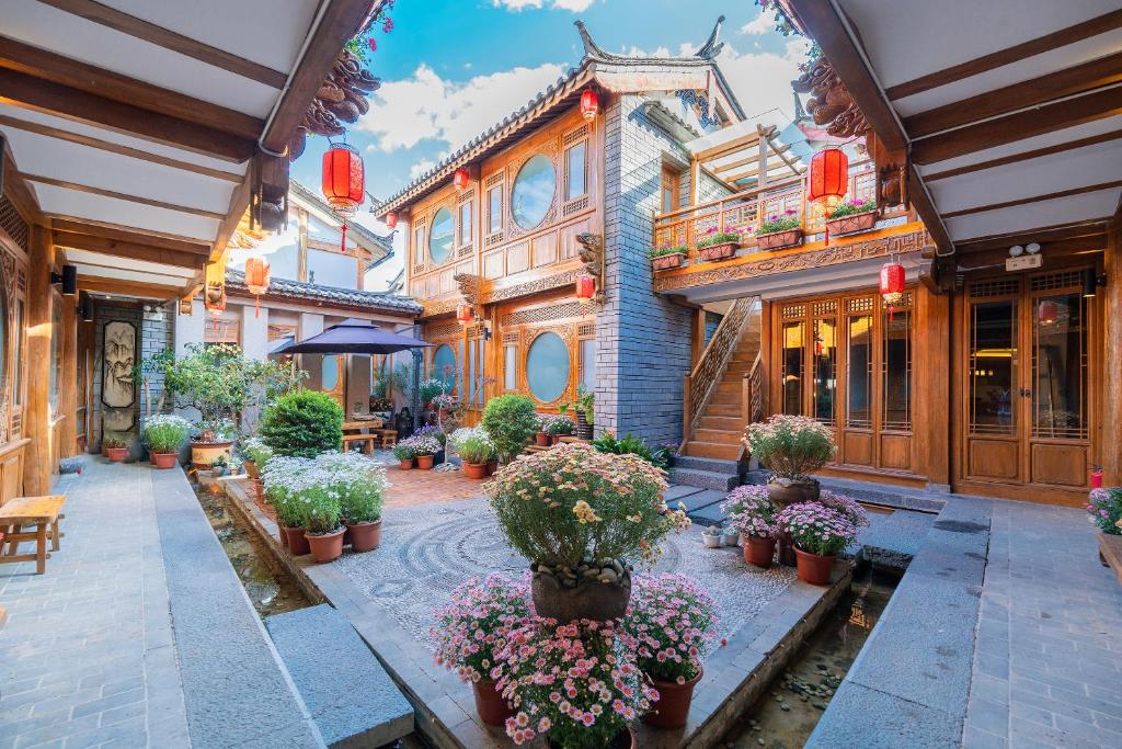 a group of buildings with potted plants and flowers at Shile Inn in Lijiang
