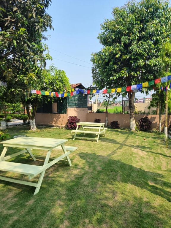 two picnic tables in a yard with flags at Hotel Tree Tops- A Serene Friendly Hotel in Sauraha in Chitwan