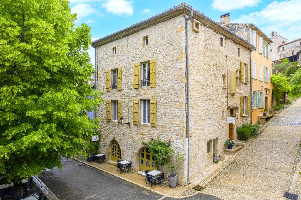 een oud stenen gebouw met een boom ervoor bij Sweet Home Cornelia in Bruniquel