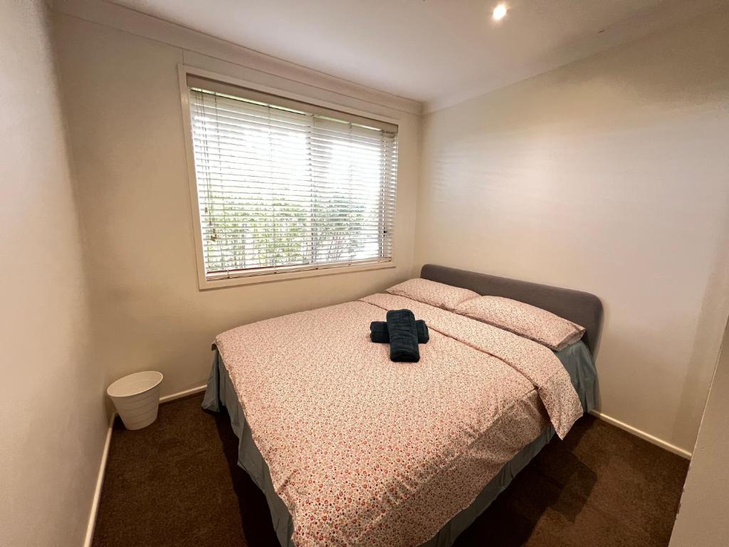 un dormitorio con una cama y una ventana en O Room, en Toongabbie