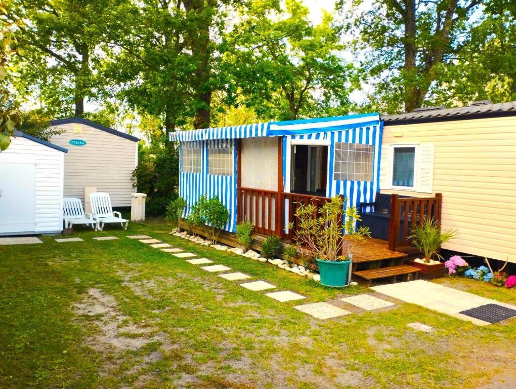 une petite maison bleue et blanche dans une cour dans l'établissement MOBIL-HOME 6 pers, 40 M2, 2 CH, 2 SDB, à Saint-Augustin