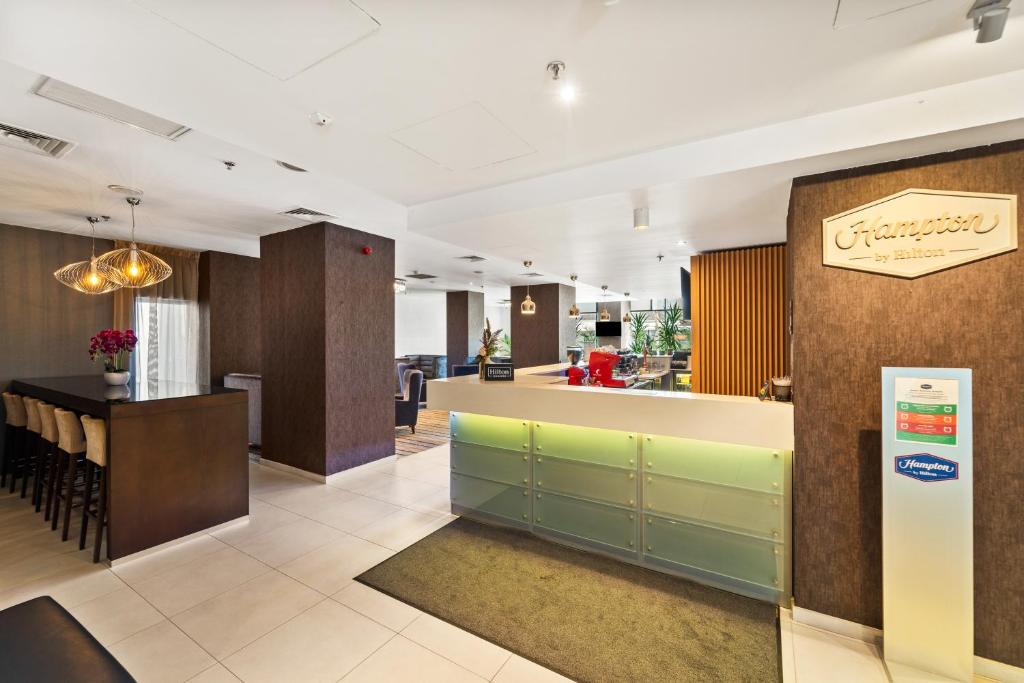 a lobby with a bar and a restaurant at Hampton by Hilton Cluj-Napoca in Cluj-Napoca