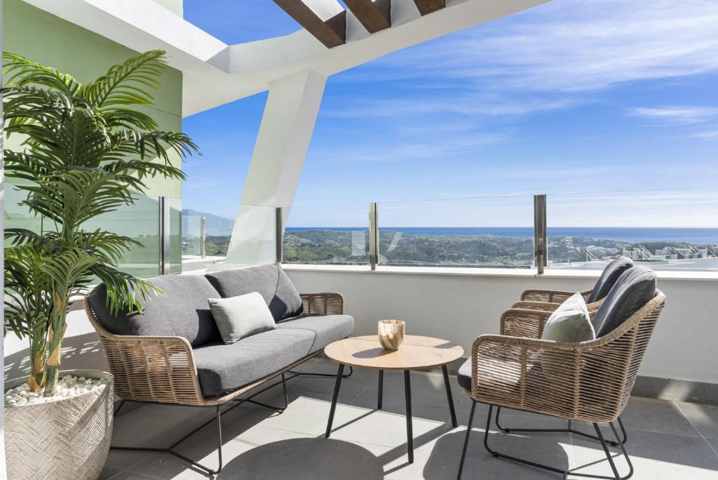 een woonkamer met een bank en stoelen en grote ramen bij VIVI Homes - Bonita del Sol Beach, Pool, Garden, GYM & SPA in La Cala de Mijas