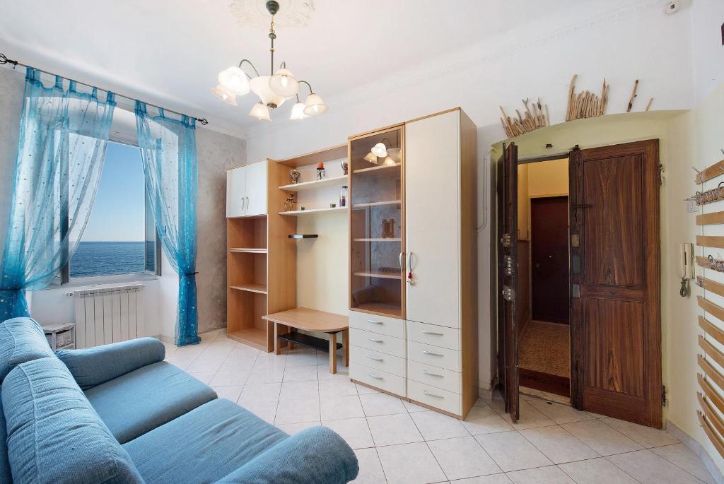 ein Wohnzimmer mit einem blauen Sofa und einem Fenster in der Unterkunft La Finestra sul Mare in Genua