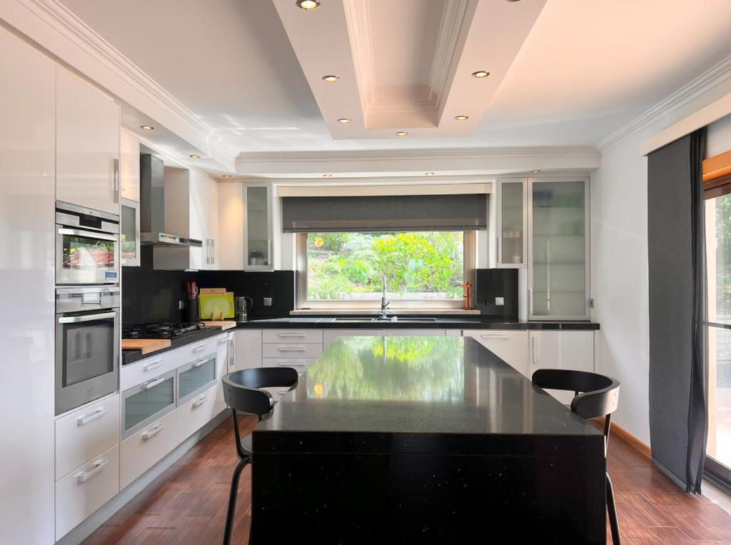 a large kitchen with a large black counter top at Luxuosa Vila Alvorninha in Alvorninha