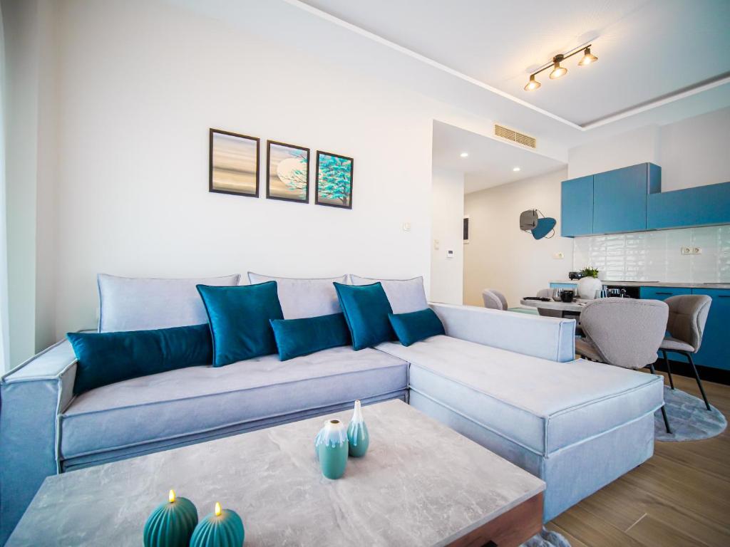 a living room with a blue couch and a table at Divino Inn in Volos