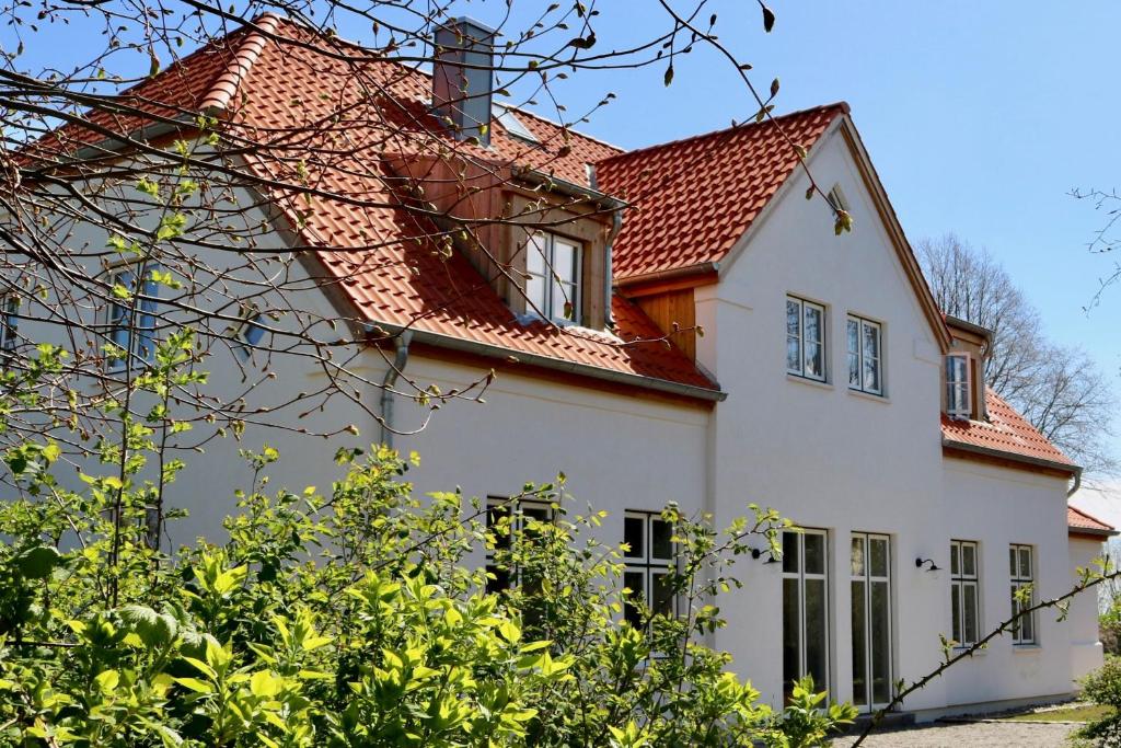 a white house with a red roof at Kleiner Caecilienhof in Pommerby