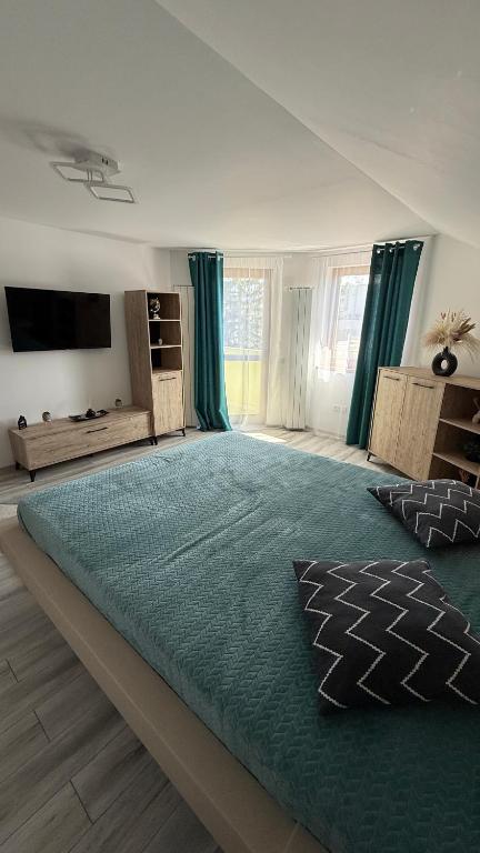 a large bedroom with a large bed with a green rug at Piatra Craiului Retreat in Zărneşti