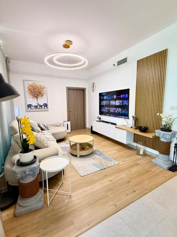 a living room with a couch and a tv at Luxury 1BR Apartment in NYU Saadiyat - Furnished in Abu Dhabi