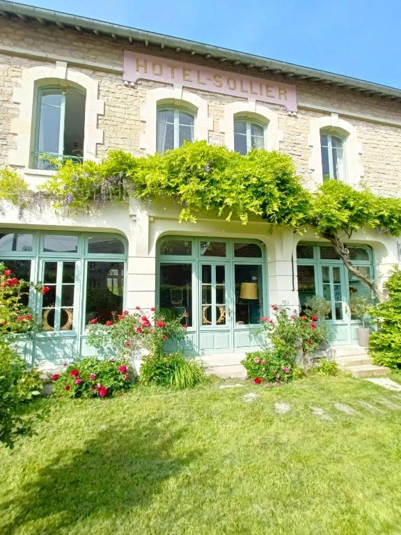 un bâtiment avec des fleurs devant lui dans l'établissement Maison Sollier, à Sainte-Croix