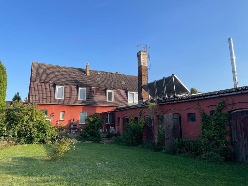 an old house with a grass yard in front of it at Großzügige Ferienwohnung nahe Berlin in Nauen