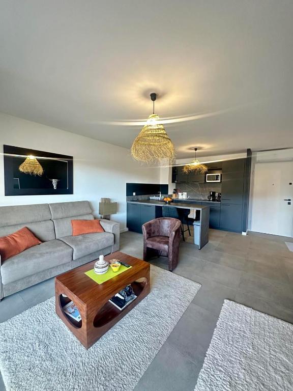un salon avec un canapé et une table dans l'établissement Appartement neuf confortable, à LʼÎle-Rousse