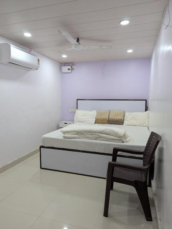 a bedroom with a bed and a chair in it at Meenakshi Guest House in Varanasi