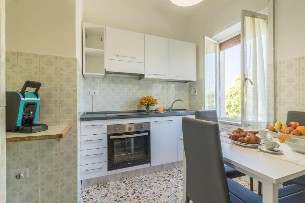 una cucina con mobili bianchi e un tavolo con una fruttiera di Riva Verde a Bolsena