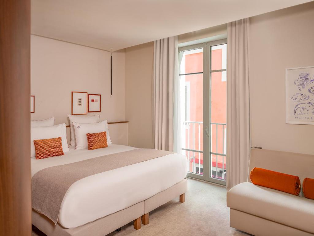 a bedroom with a large bed and a window at Hôtel Liautaud Rooftop Cassis in Cassis