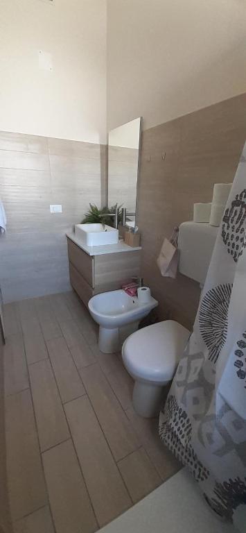 a bathroom with two toilets and a sink and a bed at Villa Manuela in Silvi Marina