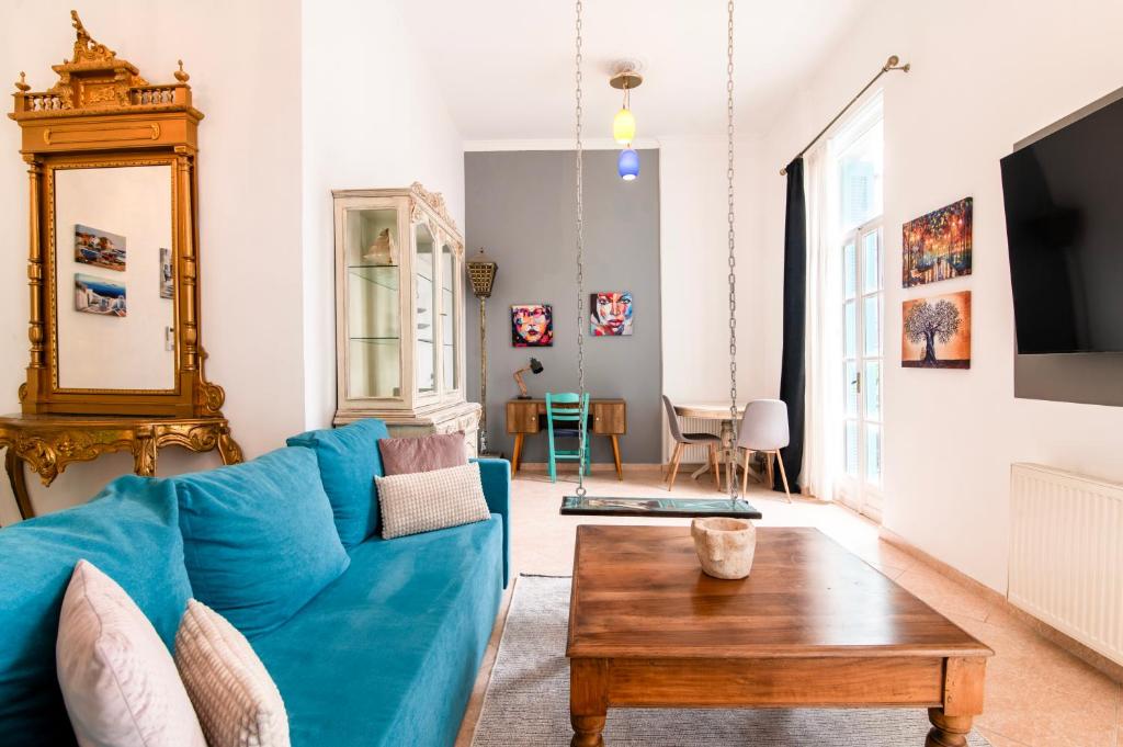 een woonkamer met een blauwe bank en een tafel bij Neoclassical Loft in Monastiraki - Acropolis and metro in Athene