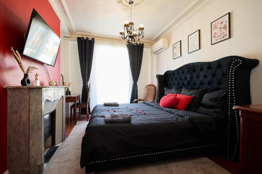- une chambre avec un lit noir et des oreillers rouges dans l'établissement Suite romantique - Carré d'Or Nice proche de la mer, à Nice