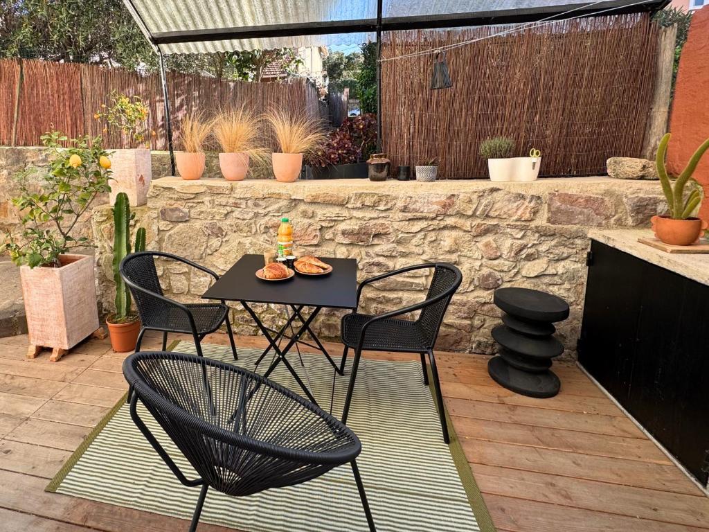 un patio avec une table et des chaises sur un patio dans l'établissement Studio de charme centre ville, proche plage & gare, à Saint-Raphaël