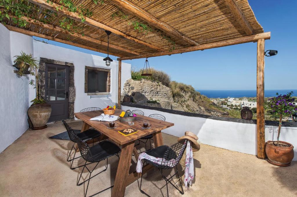 VourvoúlosにあるOld Vourvoulos Housesの海の景色を望むパティオ(木製テーブル付)