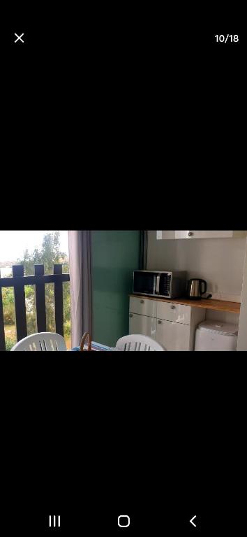 une photo d'une cuisine avec une table et des chaises dans l'établissement Appartement en résidence vue sur mer, au Barcarès