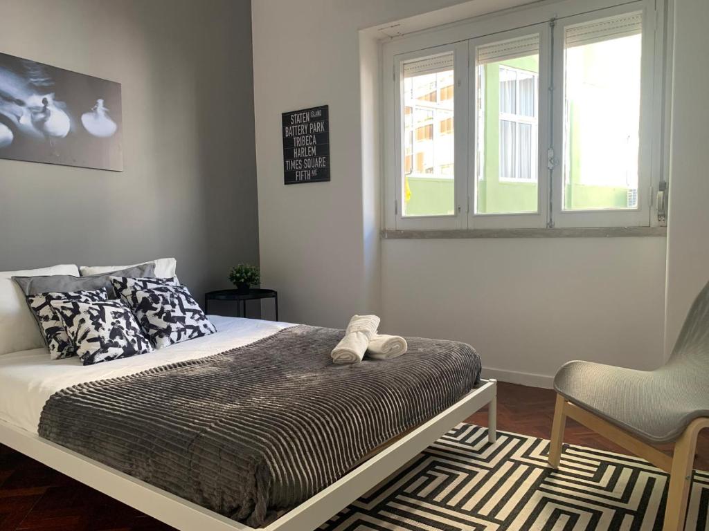 Un dormitorio con una cama y una silla y una ventana. en Central Lisbon rooms, best location for tourists, en Lisboa