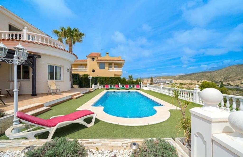 a villa with a swimming pool and a house at Casa Violetta in Alicante