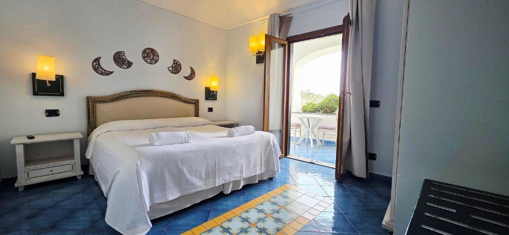 sypialnia z 2 łóżkami i drzwiami na patio w obiekcie Hotel Myage w mieście Ischia