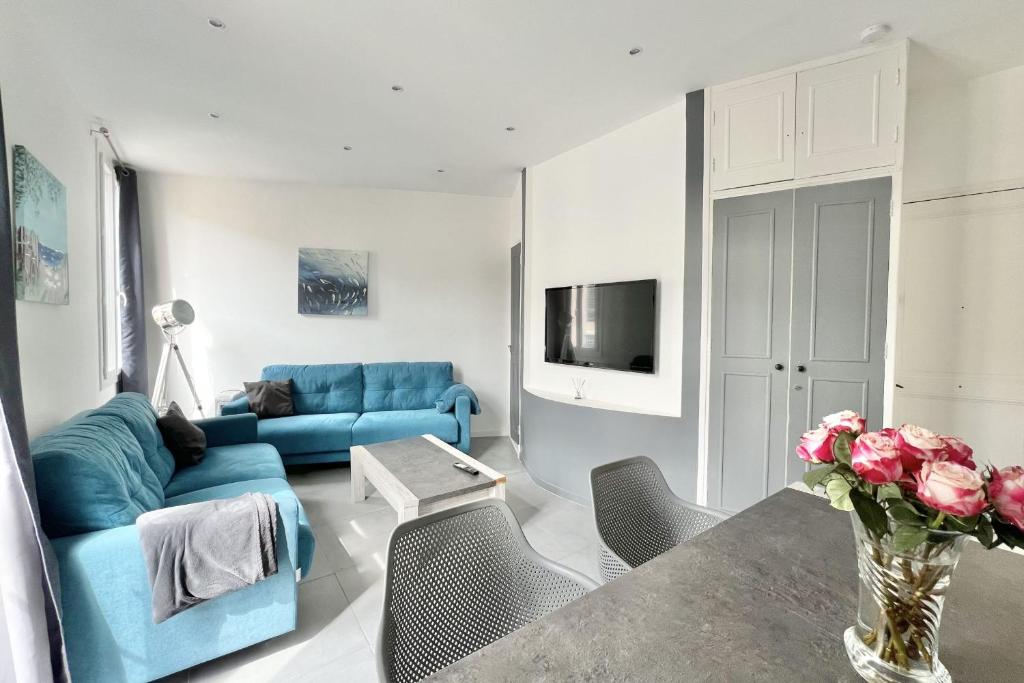 un salon avec un canapé bleu et une table dans l'établissement Apartment of 38 m2 with sea view in Cannes, à Cannes