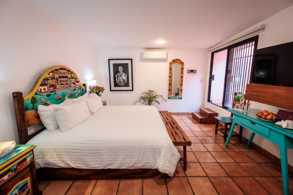 a bedroom with a large bed and a blue desk at Hotel Rosa Mexicano in Oaxaca City