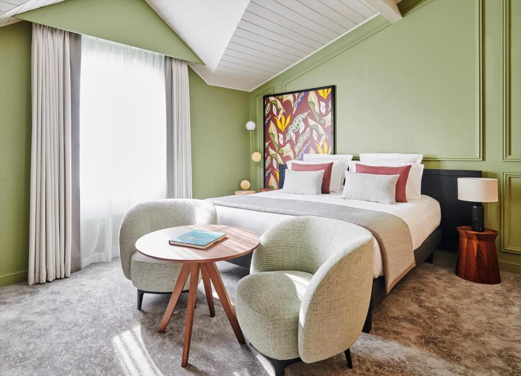 Un pat sau paturi într-o cameră la Château Hôtel Grand Barrail