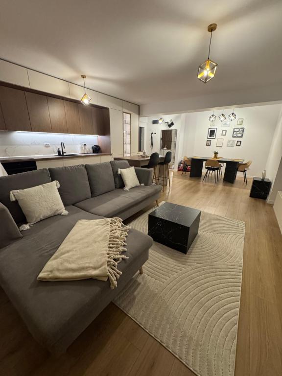 a living room with a couch and a table and a kitchen at ABE Apartment in Craiova
