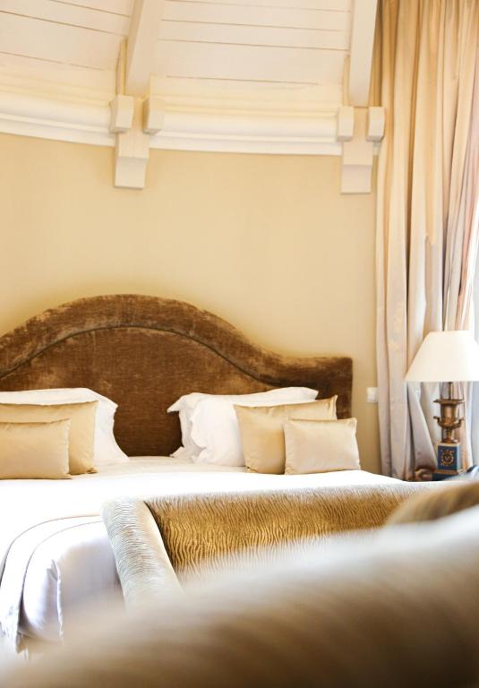 Un pat sau paturi într-o cameră la Château Hôtel Grand Barrail