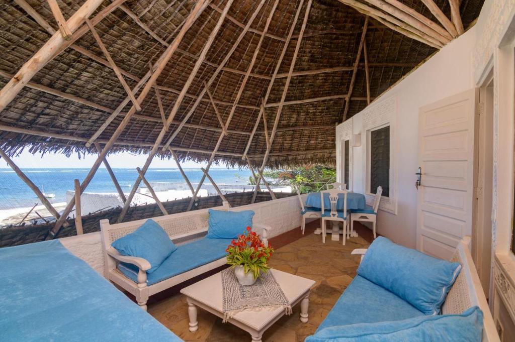 a room with two chairs and a table and the ocean at Ocean View Apartment - Malindi in Malindi