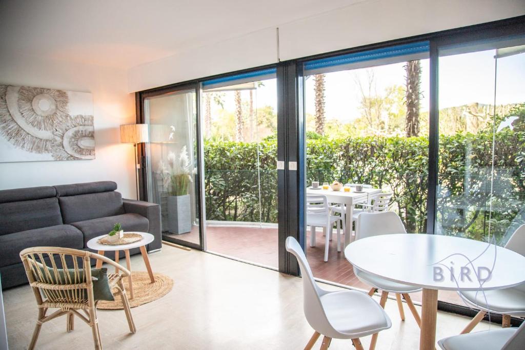 un salon avec un canapé, une table et des chaises dans l'établissement Charming apartment ideally located in Mandelieu-la-Napoule, à Mandelieu-la-Napoule