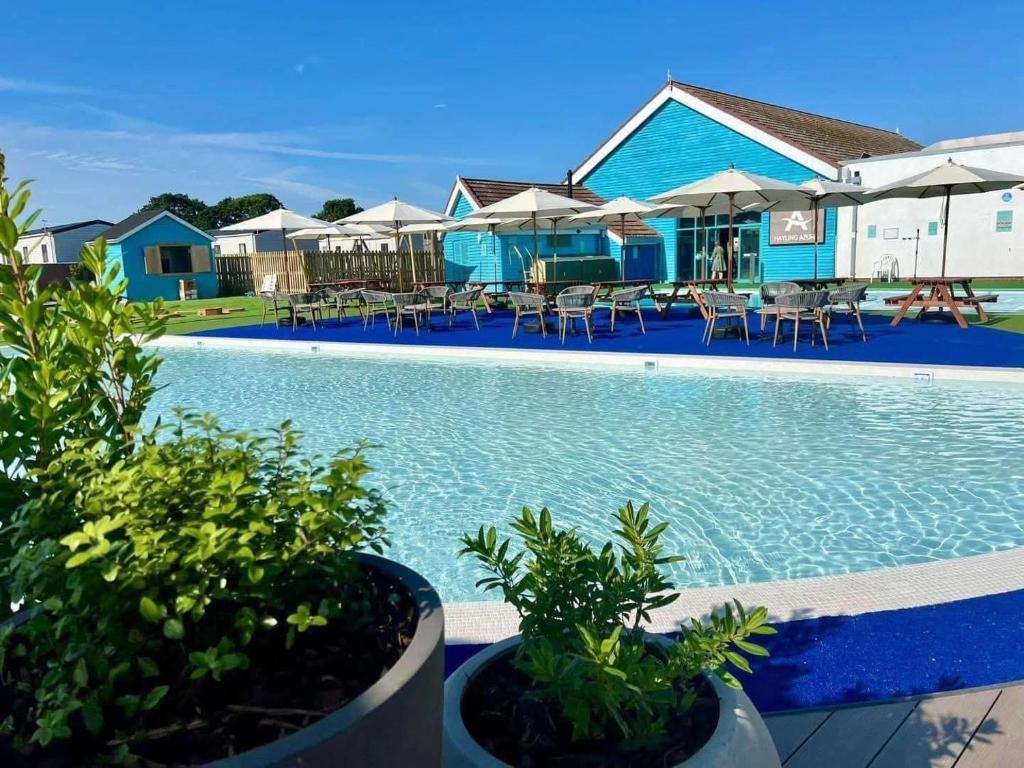 a pool with chairs and umbrellas at a resort at Hayling Island Holiday Park in South Hayling