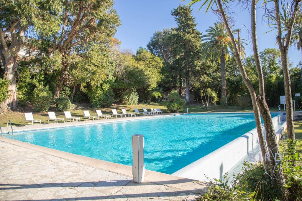 une piscine avec des chaises longues et des arbres dans l'établissement Superb apartment with pool tennis & parking, à Cannes