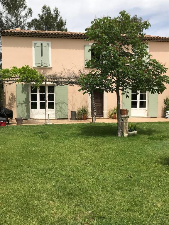 une maison avec un arbre dans la cour dans l'établissement Maison Provencale avec piscine, à Saint-Maximin-la-Sainte-Baume