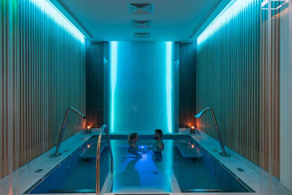two people in a swimming pool in a building at Grand Hotel & Riviera in Lido di Camaiore